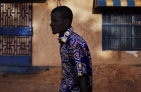 A man walks past a sign reading "Niger" in Niamey