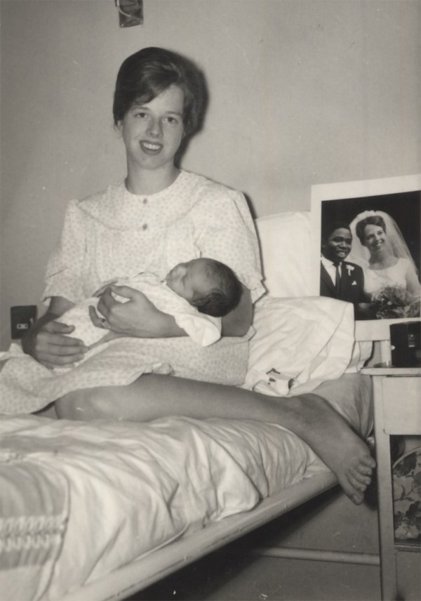 Holding our first child at Island Maternity Hospital in June 1965; I brought our wedding photo to display since Clem was away in Taiwan