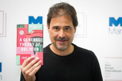 Angolan author Jose Eduardo Agualusa poses for a photograph with his book A General Theory of Oblivion at a photocall in London on May 15, 2016, ahead of tomorrow's announcement of the winner of the 2016 Man Booker International Prize. / AFP / Leon NEAL (Photo credit should read LEON NEAL/AFP/Getty Images)